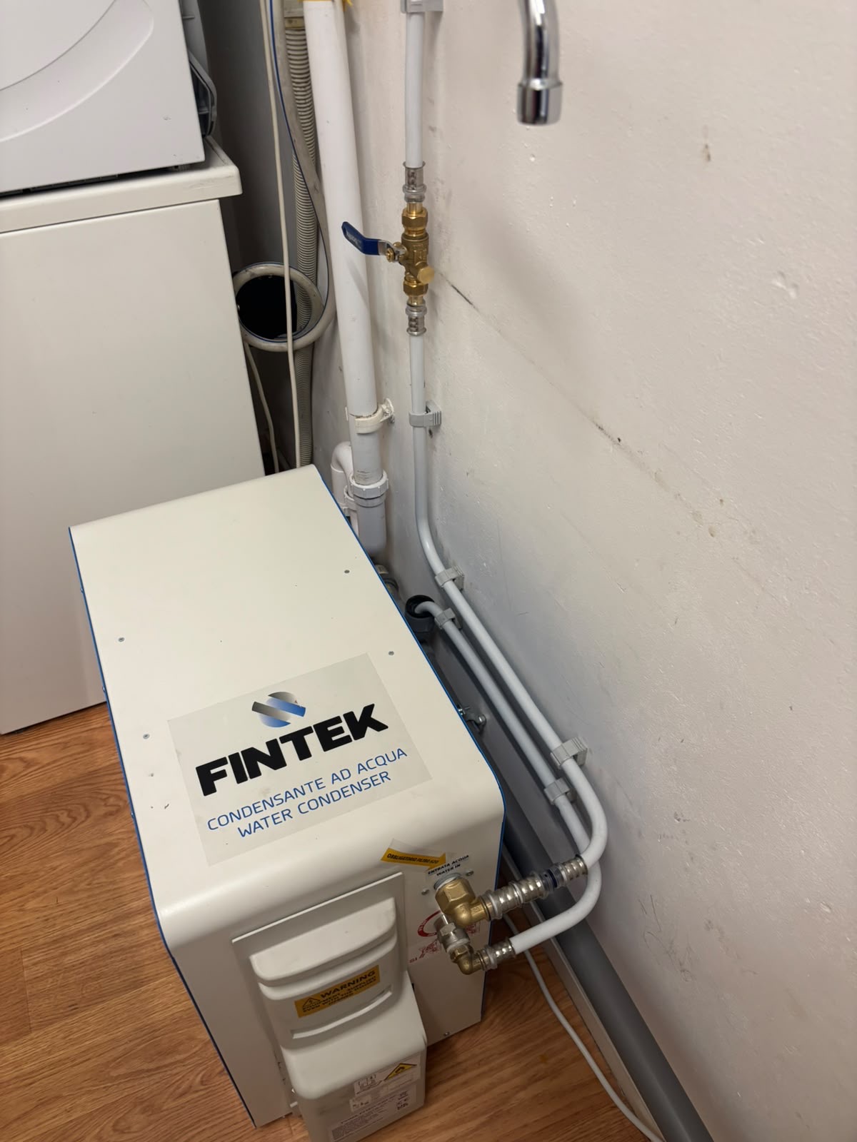 Fintek watercondenser in een technische ruimte, aangesloten op de waterleiding zonder buitenunit